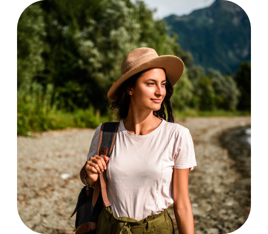 A traveller walking a gravel path with mountains in the background